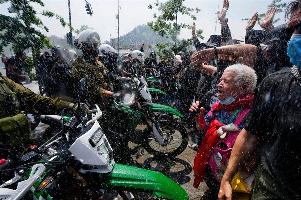 Die Polizei setzt während eines Marsches anlässlich des 7. Jahrestags des sozialen Aufstands in Chile im Jahr 2019 einen Wasserwerfer ein, um Demonstranten zu vertreiben, die gegen geplante Ausgabenkürzungen der Regierung protestieren.Esteban Felix/AP/dpa