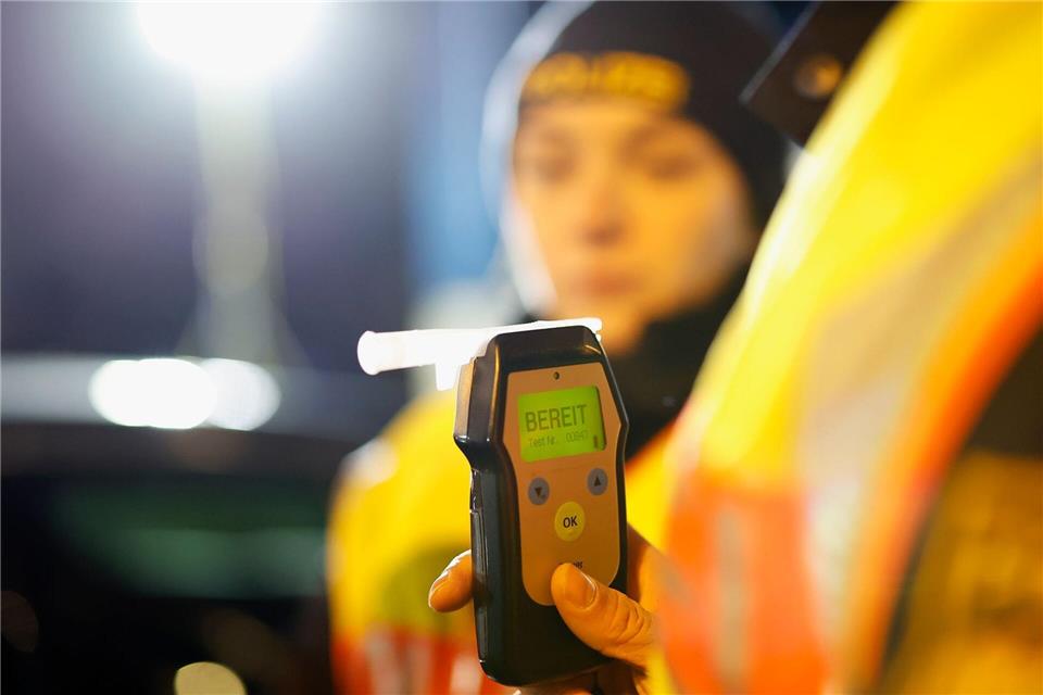 Die Polizisten führen bei dem Traktorfahrer einen Alkoholtest durch. (Symbolbild)Heiko Becker/dpa