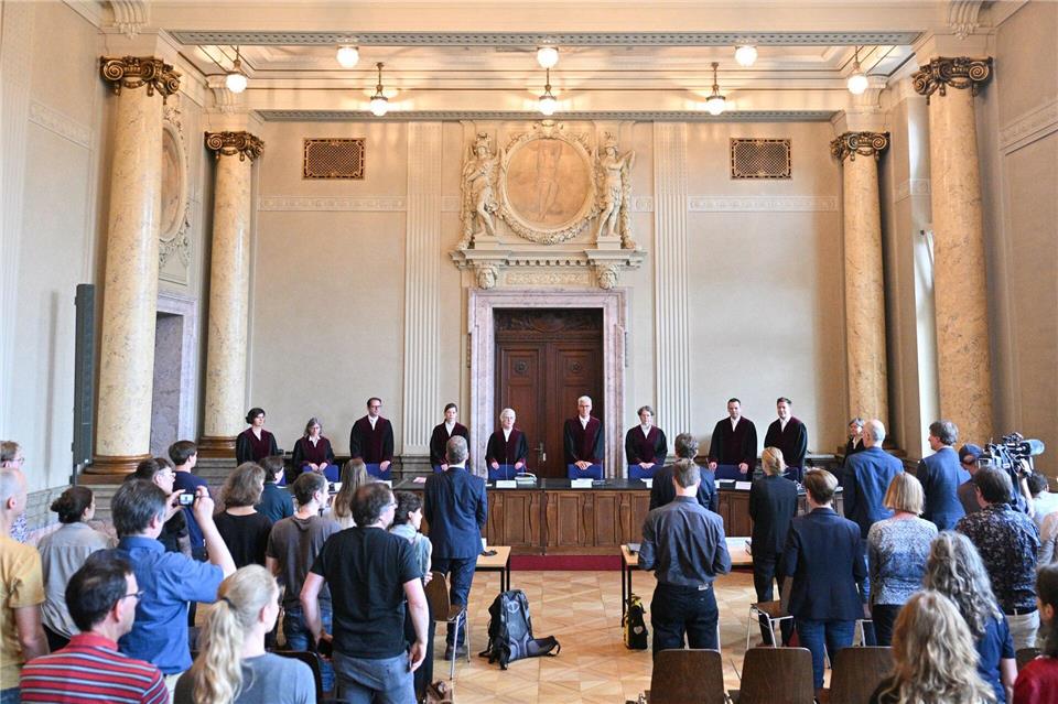 Die Richter des Verfassungsgerichtshofs stehen vor der Urteilsverkündung im Saal.Sebastian Christoph Gollnow/dpa