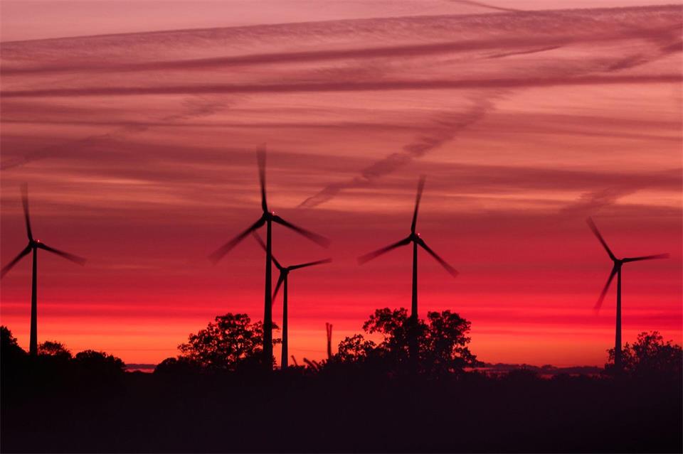 Die Rotoren von Windkraftanlagen drehen sich kurz nach Sonnenuntergang in einem Windpark in Mecklenburg-Vorpommern.Jens Büttner/dpa