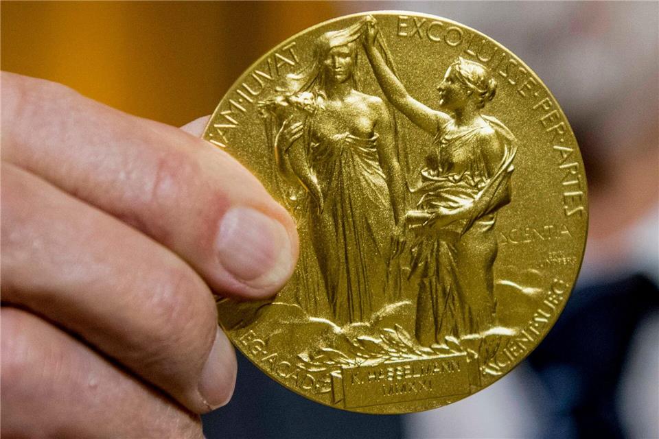 Physik-Nobelpreis: Grundlage für neue Ära der Quantentechnik Die Rückseite der Nobel-Medaille für Physik stellt die Natur in Form einer Göttin dar, die ein Füllhorn hält. Der Schleier, der ihr Gesicht bedeckt, wird vom Genie der Wissenschaft hochgehalten. (Archivbild)Stefanie Loos/AP-Pool/dpa