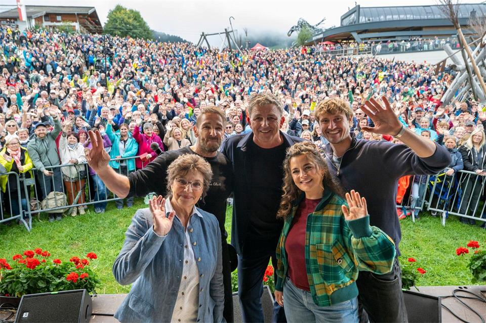 Die Schauspieler Monika Baumgartner (l-r), Mark Keller, Hans Sigl, Ronja Forcher und Frederic Brossier stehen beim „Bergdoktor-Bergfest“ vor großem Publikum.Peter Kneffel/dpa