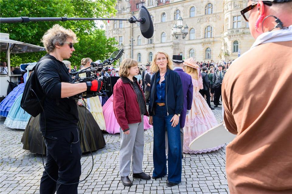 Die Schauspielerinnen Luise von Stein (l) und Maria Furtwängler stehen bei Dreharbeiten für einen neuen „Tatort“ inmitten des realen Schützenausmarsches am Neuen Rathaus.Julian Stratenschulte/dpa