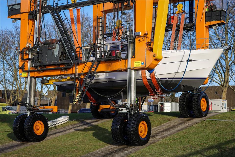 Die Schiffe werden von einem Spezialkran aus dem Rhein gehoben und kommen dann auf Tieflader, die sie in die Messehallen bringen. Christoph Reichwein/dpa