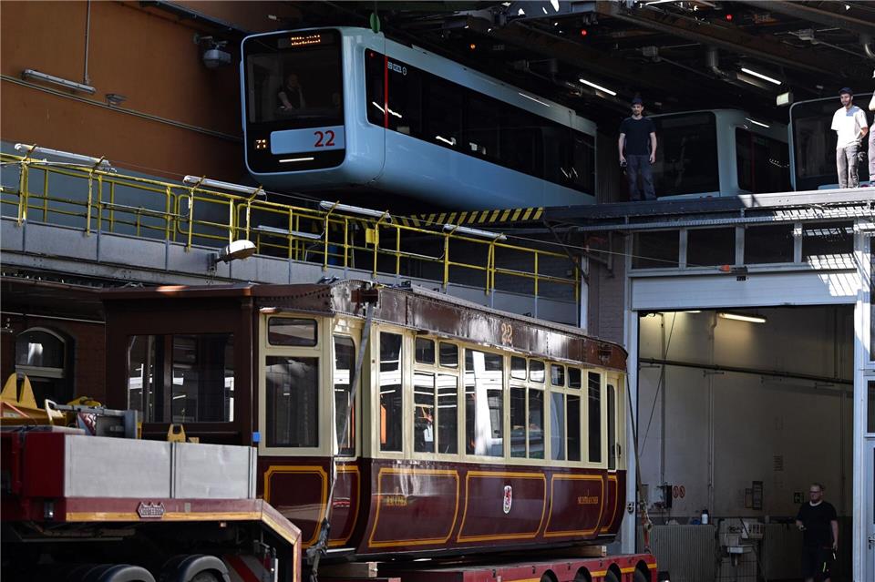 Die Schwebebahn gestern und heute. Ein Wagen der ersten Baureihe 1900 steht auf einem Tieflader unter einem Wagen der aktuellen Baureihe in der Werkstatt der Schwebebahn. (Archivbild)Federico Gambarini/dpa