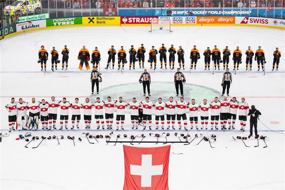 Die Schweizer (unten) und das deutsche Team steht auf dem Eis.Claudio Thoma/KEYSTONE/dpa