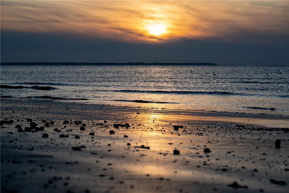 Die Sonne geht am Strand der Insel Langeoog über der Nordsee unter.Hauke-Christian Dittrich/dpa