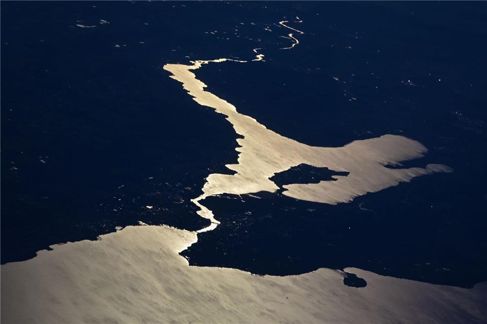 Die Sonne reflektiert sich im Bodensee, während die Stadt Konstanz, die Inseln Reichenau und Mainau sowie der Untersee und der Rhein zu sehen sind. (Aufnahme aus einem Flugzeug)Sebastian Gollnow/dpa