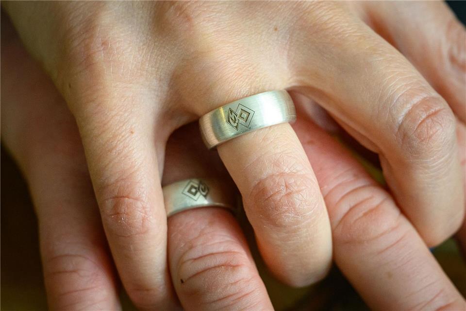 Die Vereinswappen der rivalisierenden Fußballvereine Hamburger SV und SV Werder Bremen sind auf den Eheringen von Christine Friede-Schinzel und Peter Schinzel vereint. Jonas Walzberg/dpa