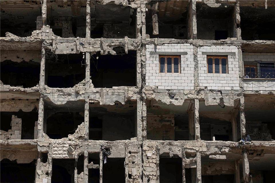 Die Wände und Fenster einer kürzlich restaurierten Wohnung ragen aus einem beschädigten Wohnhaus im vom Krieg zerstörten Viertel Al-Waer heraus.Ghaith Alsayed/AP/dpa