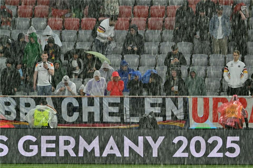 Die Zuschauer versuchten, irgendwie trocken zu bleiben.Peter Kneffel/dpa