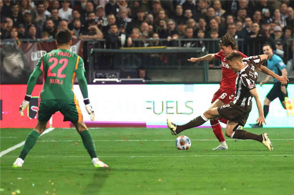 Die aus Sicht von Alexander Blessin strittige Szene vor dem Strafstoß: Kölns Jakub Kaminski (M,) und Karol Mets (FC St. Pauli) kämpfen um den Ball.Christian Charisius/dpa