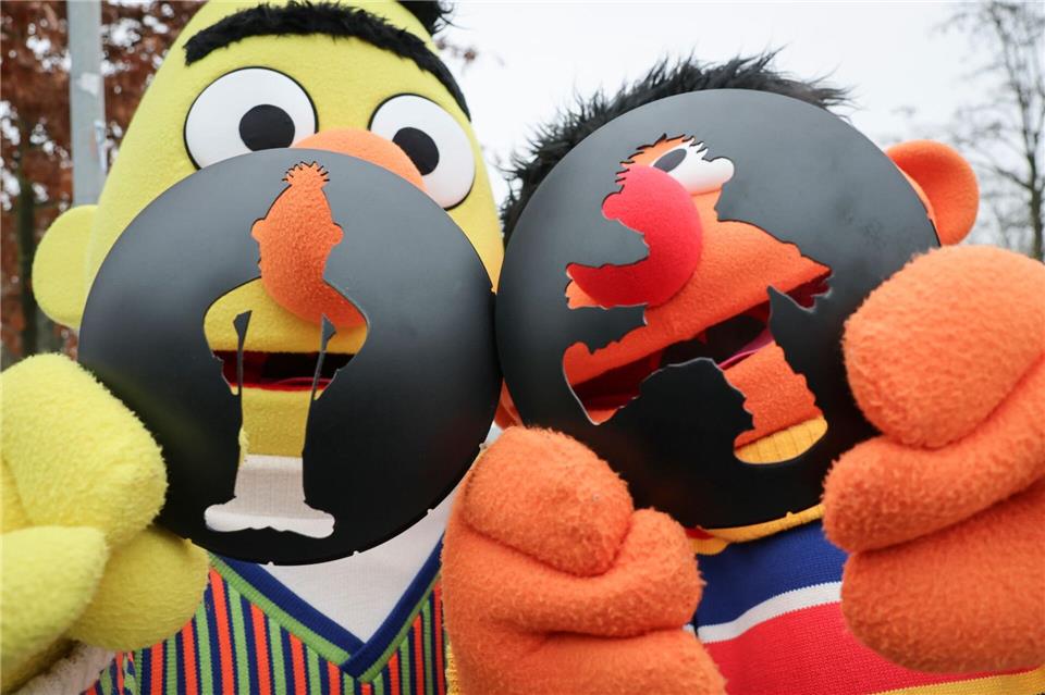 Die beiden Figuren von Ernie und Bert aus der Sesamstraße sind bei der Montage und Einweihung einer Fußgängerampel mit den Sesamstraßenfiguren in Hamburg dabei.Christian Charisius/dpa