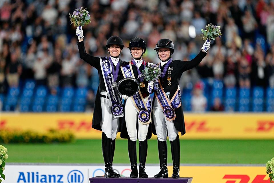 Die britische Dressurreiterin Charlotte Fry (M), die deutsche Dressurreiterin Isabell Werth (r) und die dänische Dressurreiterin Cathrine Laudrup-Dufour stehen bei der Reit-WM in Aachen auf dem Podest nebeneinander.Uwe Anspach/dpa