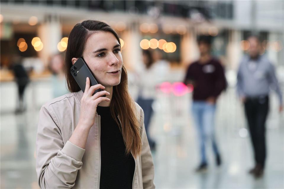 Die für KI zuständige Telekom-Mitarbeiterin Lena Drubel führt bei einer Testvorführung des KI-Assistenten ein Handytelefonat.Oliver Berg/dpa