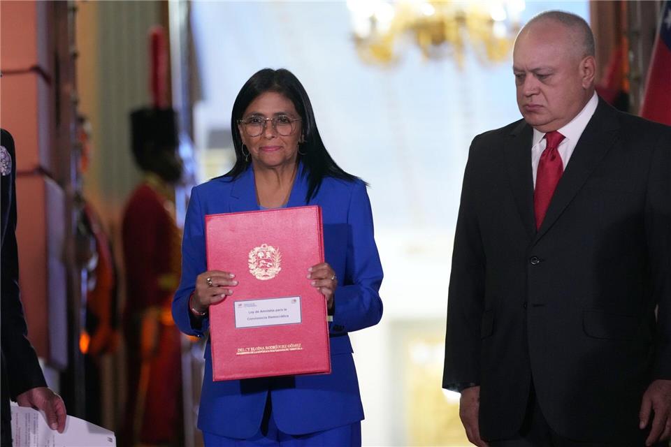 Die geschäftsführende Präsidentin Delcy Rodriguez hält ein verabschiedetes Amnestiegesetz hoch.Ariana Cubillos/AP/dpa