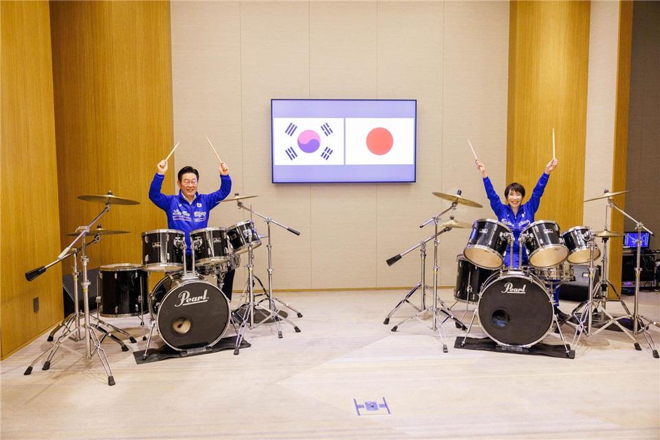 Die japanische Ministerpräsidentin Sanae Takaichi (r) und der südkoreanische Präsident Lee Jae Myung spielen Schlagzeug.Uncredited/Prime Minister’s Office of Japan/AP/dpa