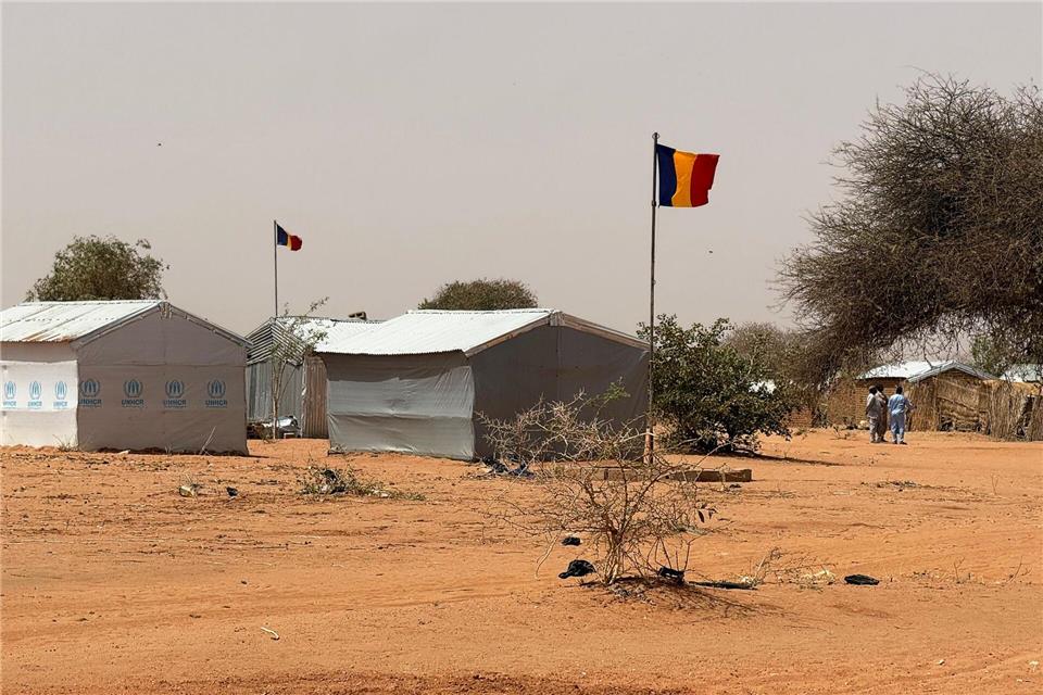 Die tschadische Fahne weht am Eingang des Flüchtlingslagers Aboutengé.Eva Krafczyk/dpa