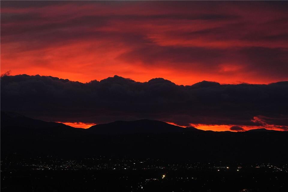 Die untergehende Sonne beleuchtet eine Wolkenbank, die über den Rocky Mountains schwebt, während ein Sturm über die Front Range von Colorado fegt.David Zalubowski/AP/dpa