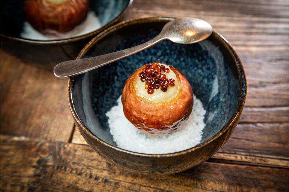 Diese Vorspeise schindet Eindruck: Die Zwiebel wird langsam bei niedriger Temperatur eingekocht und dann gefüllt. Getoppt wird sie mit Linsen und auf einem Bett aus Meersalz serviert. Christin Klose/dpa-tmn