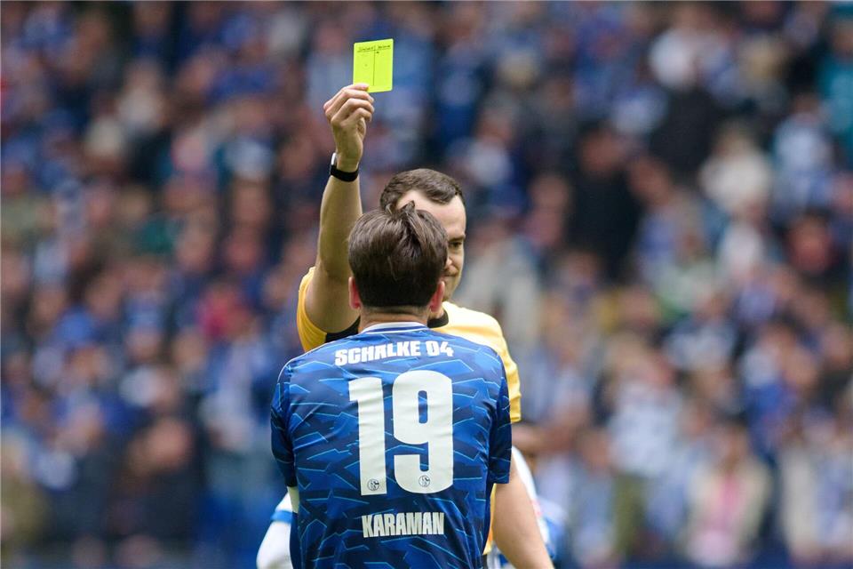 Diese gelbe Karte im Spiel gegen Karlsruhe bedeutete für Schalkes Kapitän und Toptorschützen  Kenan Karaman, dass er im Spitzenspiel in Elversberg gesperrt ist (Archivbild).Bernd Thissen/dpa