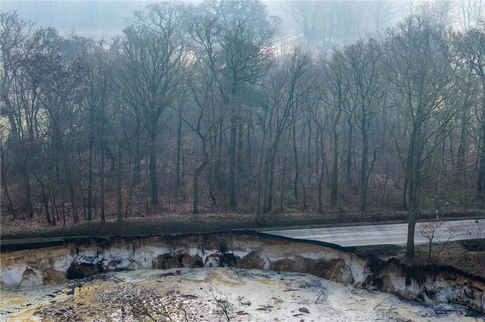 Direkt an einem Baggersee einer Quarzgrube sieht man auf dieser Drohnenaufnahme den abgesackten Bereich einer Straße. (Archivbild)Christoph Reichwein/dpa