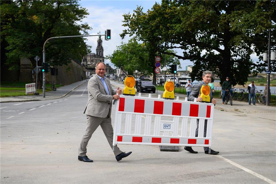 Dirk Hilbert (FDP, l), Oberbürgermeister der Stadt Dresden, und Stephan Kühn (Bündnis 90/Die Grünen), Baubürgermeister der Stadt Dresden, tragen den letzten Schrankenzaun vom Terrassenufer beiseite.Robert Michael/dpa