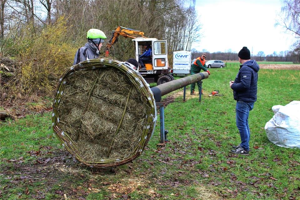 Dirk Schlattjann (v. li.), Guido Wesseling und Manfred Hartog richten das Storchennest auf.