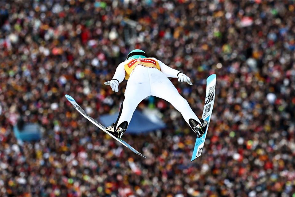 Domen Prevc glänzt vor voller Kulisse.Daniel Karmann/dpa