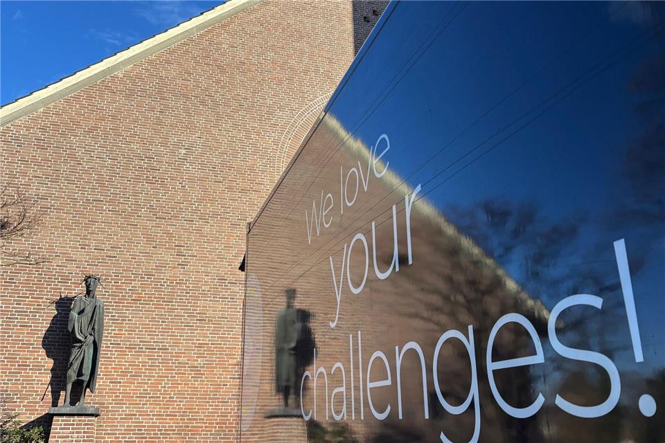Doppeldeutig: Ein Lkw stand am Mittwoch vor der Christus-König-Kirche in Gemen, um Materialien für die Ausstellung anzuliefern. „Wir lieben ihre Herausforderungen“ stand auf der Seite - und vor denen steht die Gemeinde beim angedachten Verkauf der Pfarrkirche auch.