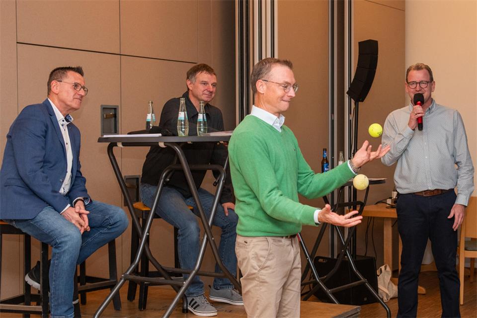 Dr. Michael Schmitt (2. v. re.) zeigt mit zwei Bällen eine Übung zum Thema Koordination. Schmitt war neben Wolfgang Fuchs (li.) und Jürgen Kaling ein Gast beim Velener „ProatCast“. Ralf Nassmacher (re.) moderierte.