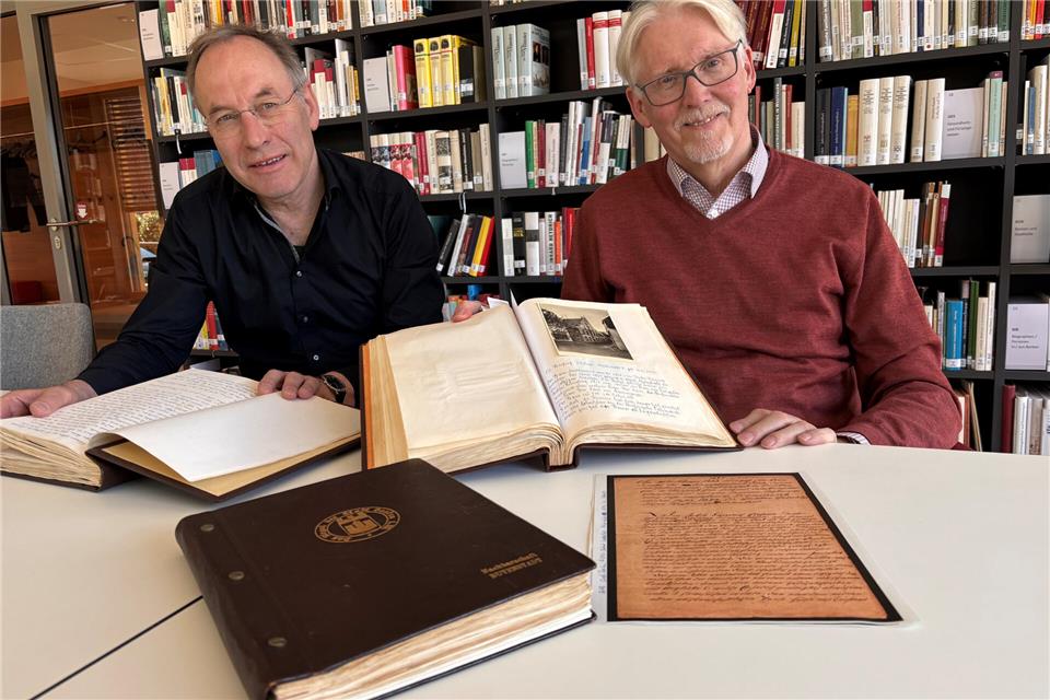 Dr. Norbert Fasse (links) und Thomas Ridder mit der Chronik der Nachbarschaft Mühlenstraße/Am Kuhm. Die beiden Historiker freuen sich über weitere Hinweise aus dem ganzen Stadtgebiet.