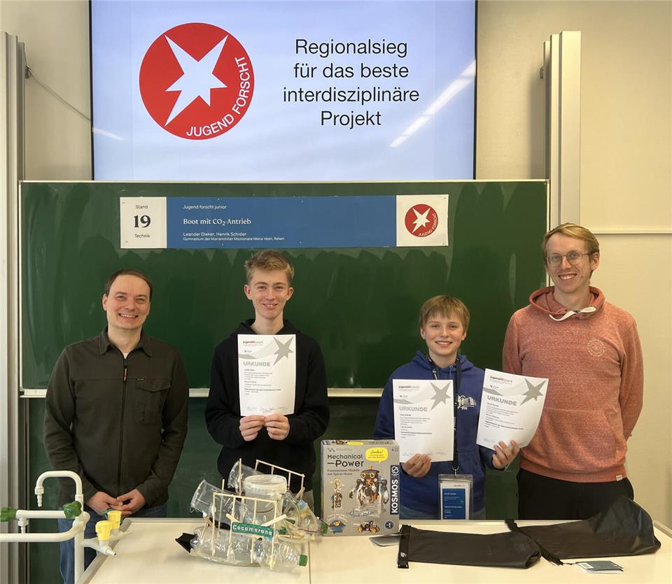 Dr. Thomas Küper (MINT-Beauftragter), Leander Dieker (Klasse 9b), Henrik Schröer (Klasse 7a) sowie Tom Korthals (Lehrer, Betreuer des MINT-Clubs) (von links) freuen sich über den Sieg der beiden Schüler.