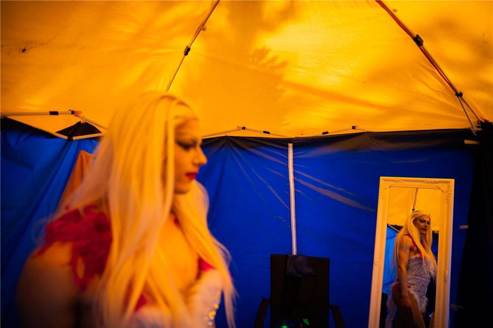 Dragqueen Janoma Bange steht beim Demokratiefest in Bad Freienwalde in einem Zelt und ist in einem Spiegel zu sehen.Christoph Soeder/dpa