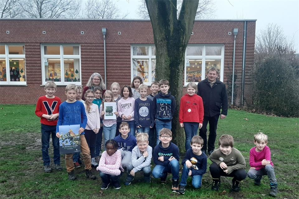 Drittklässler an „ihrem“ Silberahornbaum mit Klassenlehrerin Barbara Horbach und Franz-Josef Löchteken von der Naturfördergesellschaft für den Kreis Borken: Sie freuen sich über das gelungene Projekt.