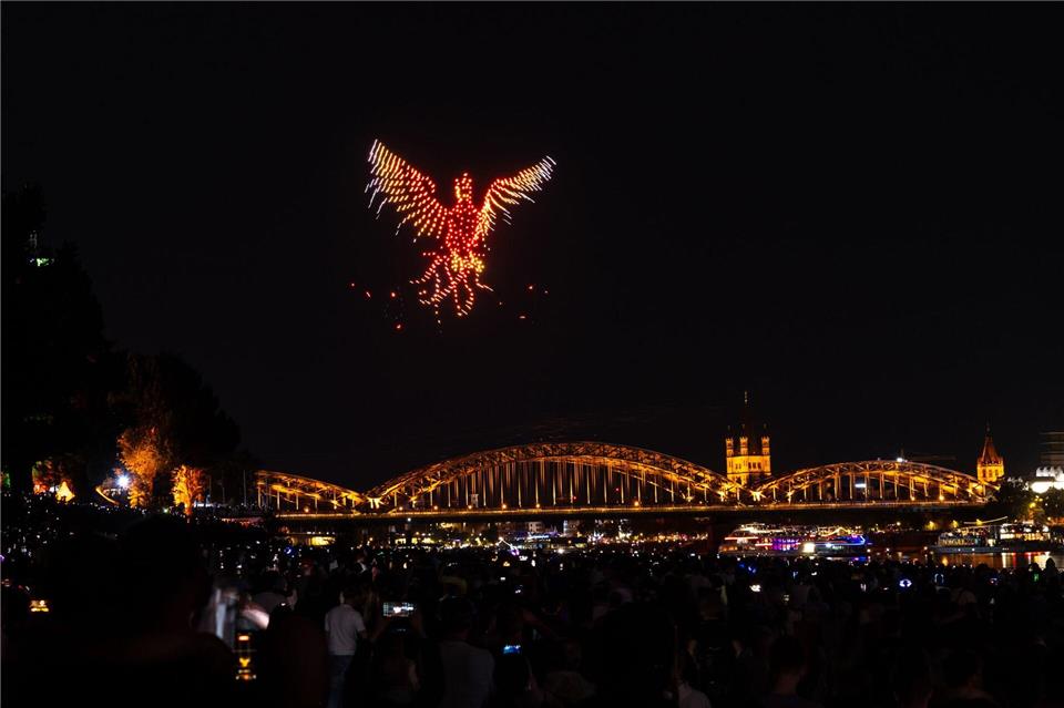 Drohnen gestalten eine Figur während des Feuerwerksspektakels „Kölner Lichter“ über dem Rhein.Christian Knieps/dpa