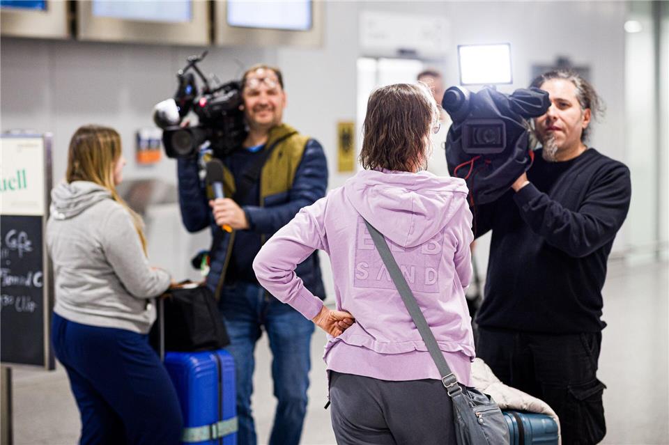 Dubai-Touristen geben nach ihrer Landung Kameramännern Interviews.Moritz Frankenberg/dpa