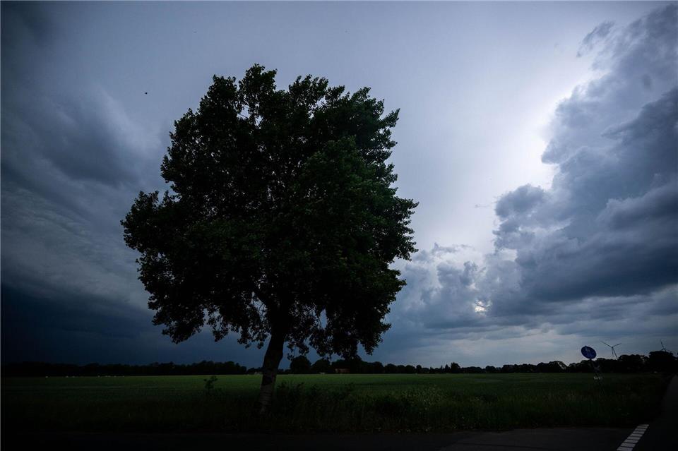 Dunkle Wolken hängen über den Feldern in Bremen.Sina Schuldt/dpa