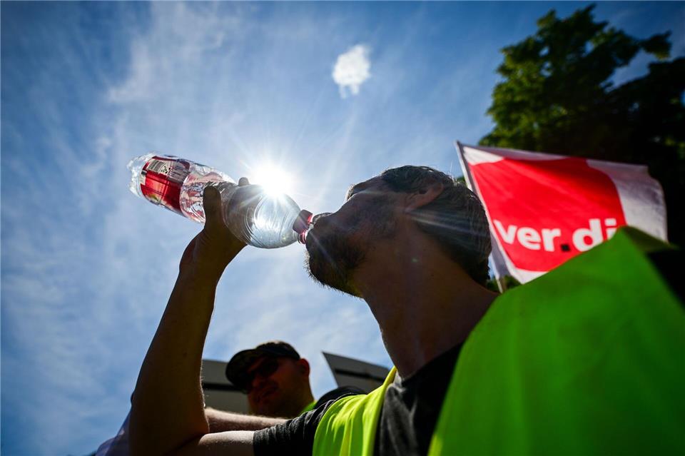 Durst im Streik: Mann trinkt bei Sommerhitze während des bundesweiten ver.di-WarnstreiksSebastian Christoph Gollnow/dpa