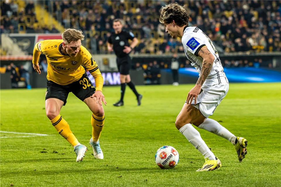 Dynamos Jonas Sterner (l) im Duell mit dem Elversberger Torschützen Nicholas Mickelson.Britta Pedersen/dpa