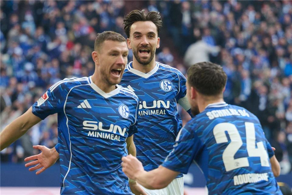 Edin Dzeko (FC Schalke 04, l-r) jubelt mit Kenan Karaman (FC Schalke 04) und Adil Aouchiche (FC Schalke 04) über seinen Treffer zum 1:0.Bernd Thissen/dpa