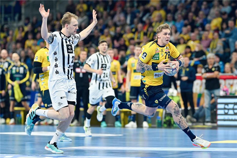 Edwind Aspenbäck (r) von den Rhein-Neckar Löwen zieht gegen den Kieler Eric Johansson davon.Uwe Anspach/dpa