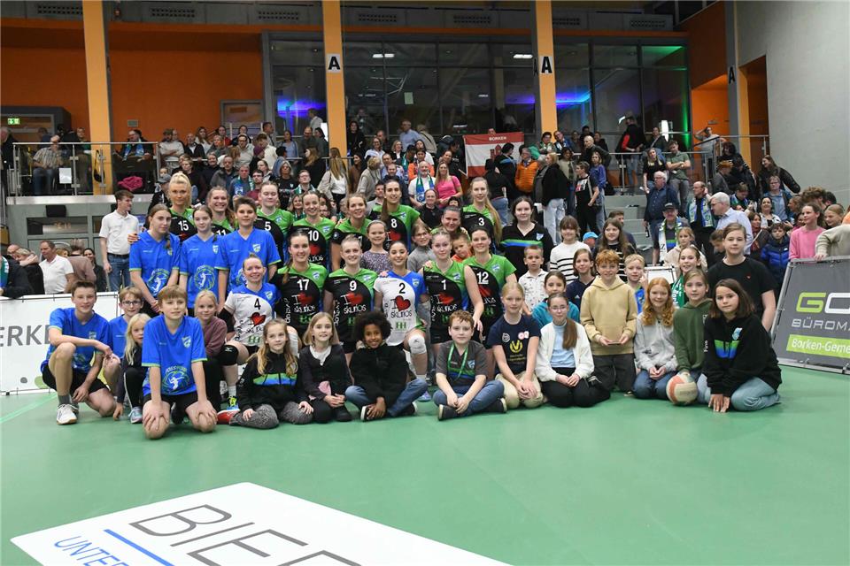 Eher ein gequältes Lächeln: Gruppenbild der Skurios Volleys nach dem 1:3 gegen Hamburg mit Ballmädchen und -jungen und jungen Fans. 
