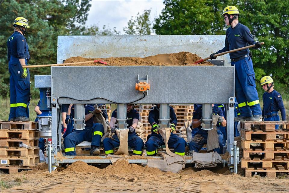 Ehrenamtliche Helfer vom THW füllen in Eisenhüttenstadt Sandsäcke gegen das Hochwasser des Flusses Oder.Patrick Pleul/dpa