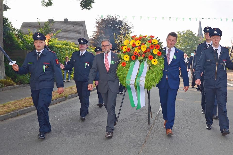 Ehrenherren Klaus Röckinghausen und Michael Heynck tragen den Kranz zum Ehrenmal. Bosse