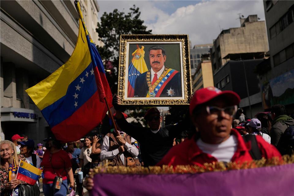 Ein Anhänger der Regierung hält ein Bild von Präsident Nicolas Maduro.Matias Delacroix/AP/dpa