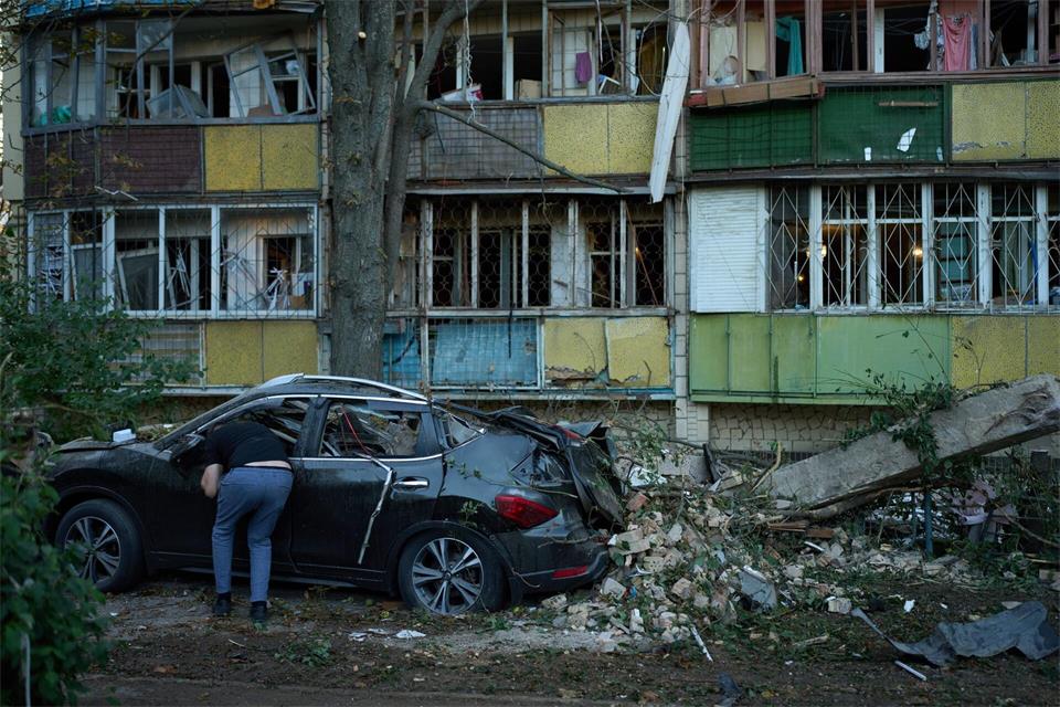 Ein Anwohner blickt nach einem nächtlichen russischen Angriff in ein zerstörtes Auto.Francisco Seco/AP/dpa