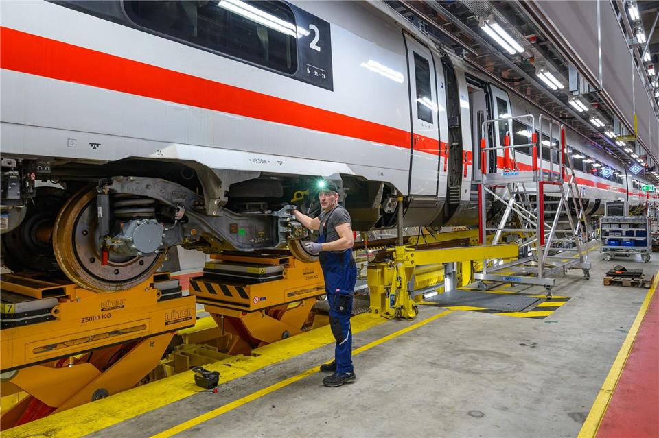 Ein Arbeiter montiert einen Radsatz im ICE-4-Instandhaltungswerk der Deutschen Bahn. Das ICE-Werk in Cottbus wird am 11.01.2025 ein Jahr alt. Im ersten Jahr nach der Inbetriebnahme wurden hier insgesamt 13 ICE-4 Züge gewartet. Für 2025 sollen bereits doppelt soviel Züge gewartet werden. Zudem solle die sogenannte schwere Instandhaltung des ICE-4 schon jetzt vollständig in der Lausitz gebündelt werden, teilte die Deutsche Bahn mit.Patrick Pleul/dpa
