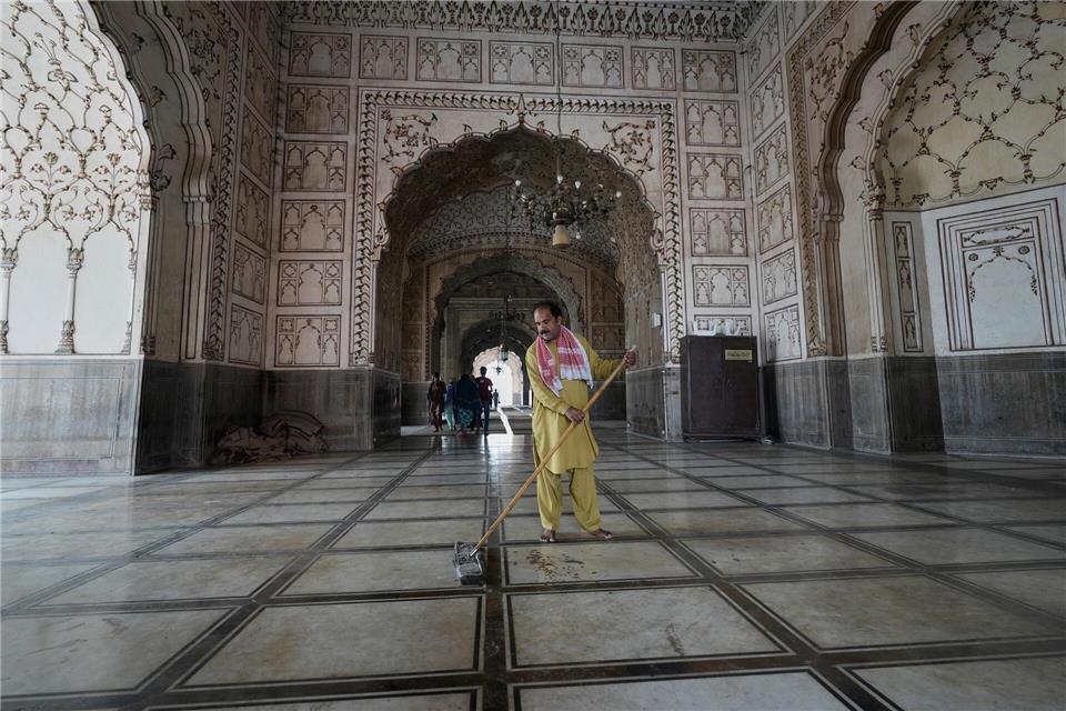 Ein Arbeiter reinigt einen Bereich der historischen Badshahi-Moschee in Vorbereitung auf den bevorstehenden muslimischen Fastenmonat Ramadan in Lahore.K.M. Chaudary/AP/dpa