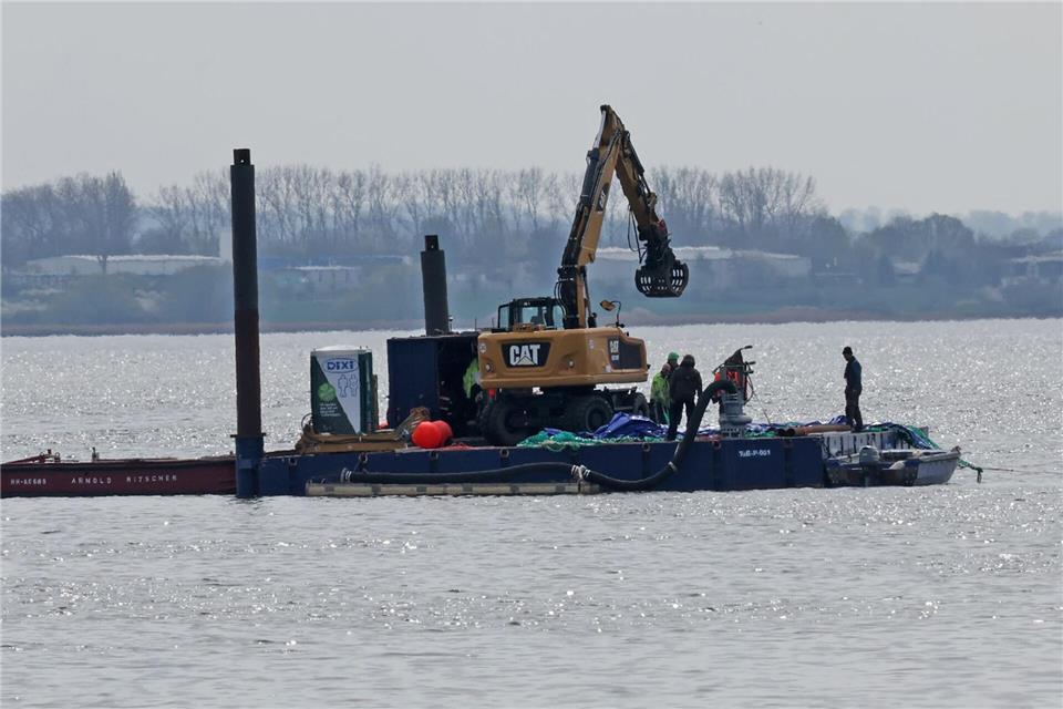 Ein Arbeitsponton mit einem speziellen Bagger und kleinere Begleitboote sind in der Nähe des gestrandeten Buckelwals vor der Insel Poel im Einsatz. Bernd Wüstneck/dpa